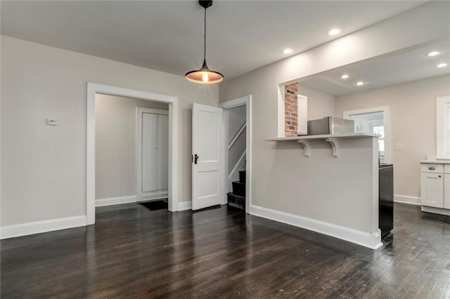 826 W 75th St, Kansas City, MO 64114 - unfurnished living room featuring stairway, dark wood-type flooring, and recessed lighting