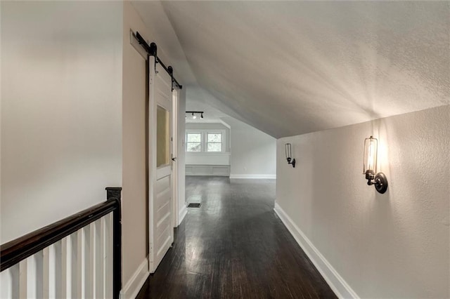 826 W 75th St, Kansas City, MO 64114 - corridor featuring lofted ceiling, dark wood-style floors, a barn door, an upstairs landing, and a textured ceiling