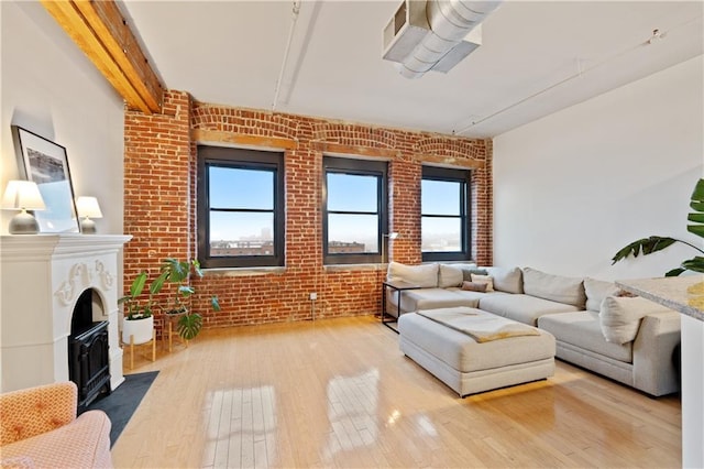 200 Main St Unit 509, Kansas City, MO 64105 - living room featuring brick wall, light wood-style floors, plenty of natural light, and a fireplace