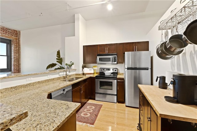 200 Main St Unit 509, Kansas City, MO 64105 - kitchen featuring appliances with stainless steel finishes, light stone counters, light wood-style flooring, and dark brown cabinets