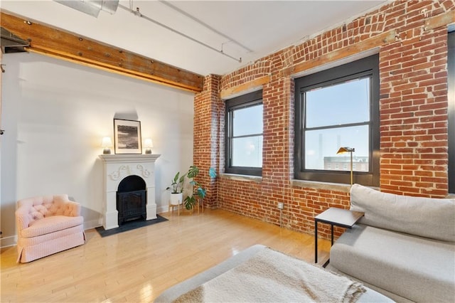 200 Main St Unit 509, Kansas City, MO 64105 - living room featuring a fireplace with flush hearth, wood finished floors, and brick wall