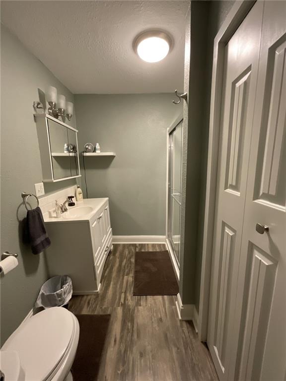 964 Cable Point Dr, Climax Springs, MO 65324 - full bath featuring a stall shower, vanity, wood finished floors, and a textured ceiling