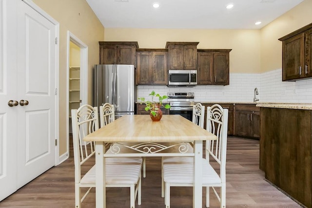 21119 E 8th St S, Independence, MO 64056 - kitchen with appliances with stainless steel finishes, dark brown cabinetry, backsplash, and recessed lighting