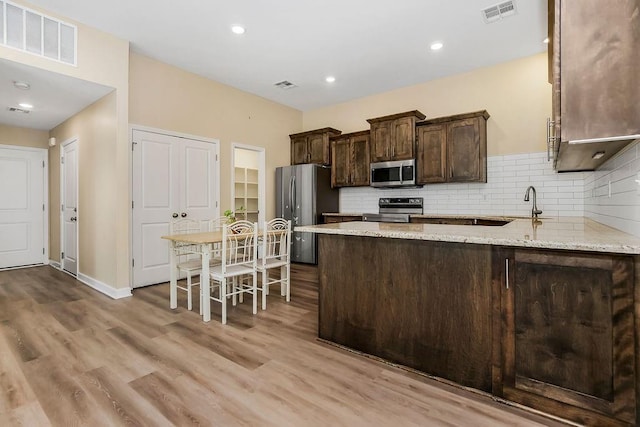 21119 E 8th St S, Independence, MO 64056 - kitchen with stainless steel appliances, dark brown cabinets, decorative backsplash, wood finished floors, and recessed lighting