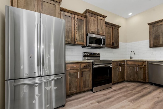 21119 E 8th St S, Independence, MO 64056 - kitchen featuring stainless steel appliances, light wood-type flooring, backsplash, dark brown cabinets, and recessed lighting