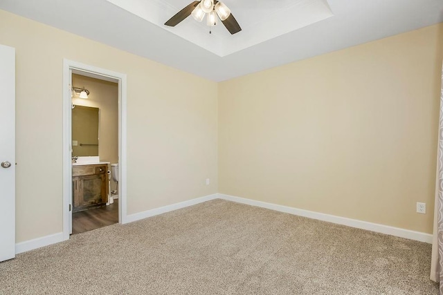 21119 E 8th St S, Independence, MO 64056 - unfurnished bedroom with carpet flooring, a tray ceiling, ensuite bathroom, and ceiling fan