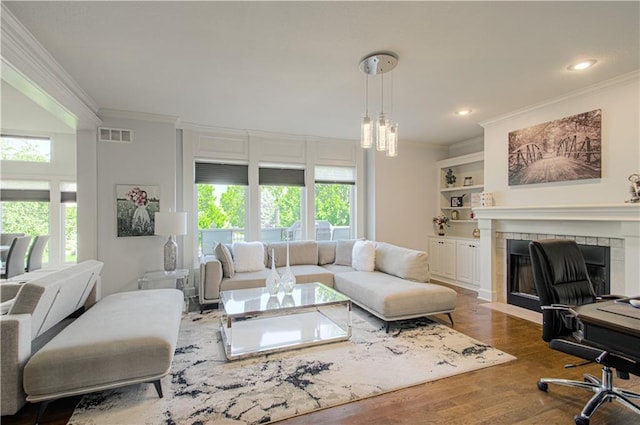 9624 N Arlington Ave, Kansas City, MO 64158 - living area with crown molding, healthy amount of natural light, wood finished floors, a tile fireplace, and recessed lighting