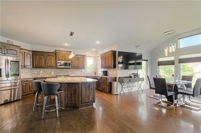 9624 N Arlington Ave, Kansas City, MO 64158 - kitchen featuring stainless steel appliances, a kitchen island, dark wood finished floors, tasteful backsplash, and pendant lighting
