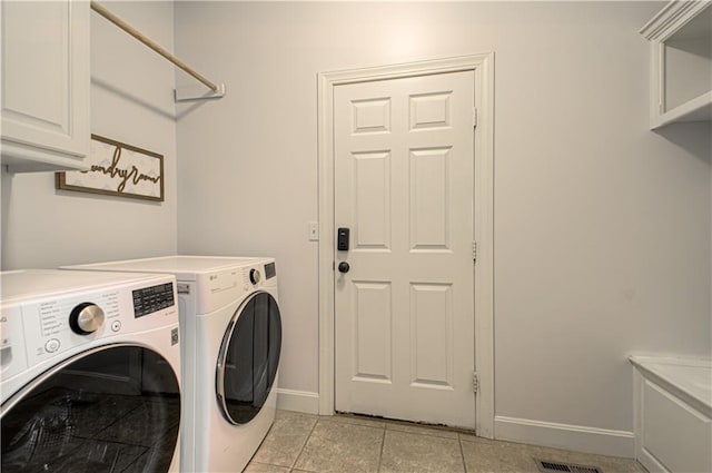 9624 N Arlington Ave, Kansas City, MO 64158 - laundry room with washer and clothes dryer, cabinet space, and light tile patterned flooring