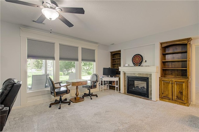 9624 N Arlington Ave, Kansas City, MO 64158 - carpeted home office with a tile fireplace, a textured ceiling, a ceiling fan, and built in shelves