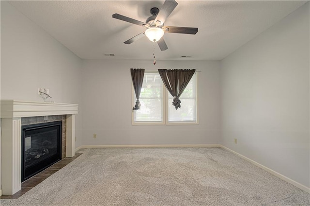 9624 N Arlington Ave, Kansas City, MO 64158 - unfurnished living room featuring carpet flooring, a ceiling fan, a tiled fireplace, and a textured ceiling