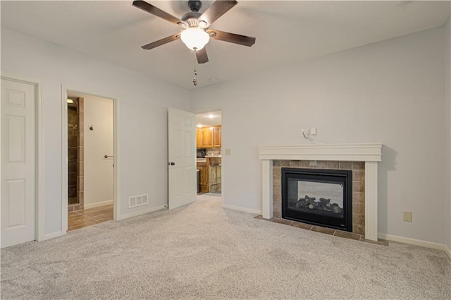 9624 N Arlington Ave, Kansas City, MO 64158 - unfurnished living room with ceiling fan, light colored carpet, and a tiled fireplace