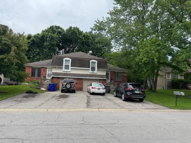 1431-33 E Penrose Ln, Olathe, KS 66062 - tri-level home featuring driveway, brick siding, and a front lawn