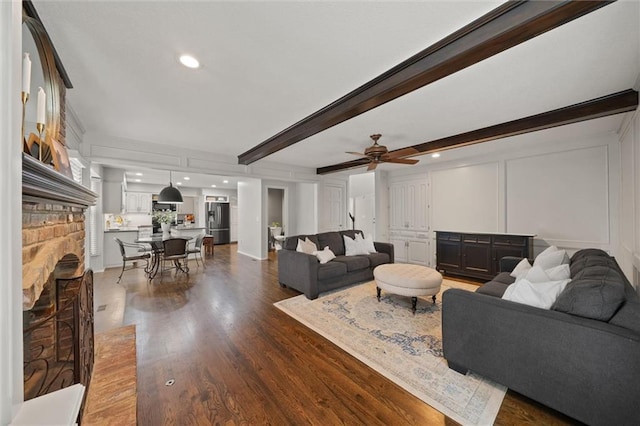 9805 W 121st Ter, Overland Park, KS 66213 - living area with wood finished floors, ceiling fan, a decorative wall, a brick fireplace, and recessed lighting