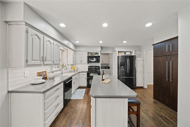 9805 W 121st Ter, Overland Park, KS 66213 - kitchen featuring black appliances, a breakfast bar, a kitchen island, dark wood-style floors, and recessed lighting
