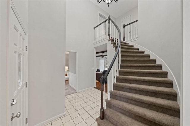 9805 W 121st Ter, Overland Park, KS 66213 - entrance foyer featuring stairway, light tile patterned floors, a chandelier, and a towering ceiling