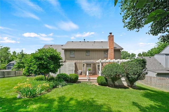 9805 W 121st Ter, Overland Park, KS 66213 - back of property featuring a fenced backyard, a pergola, a chimney, board and batten siding, and a wooden deck