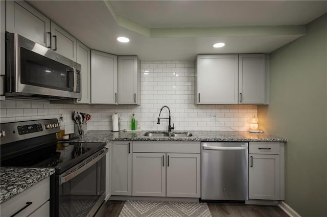 1934 E Mechanic Ave, Independence, MO 64050 - kitchen with stainless steel appliances, wood finished floors, backsplash, recessed lighting, and light stone counters