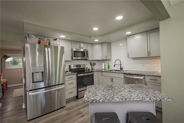 1934 E Mechanic Ave, Independence, MO 64050 - kitchen with stainless steel appliances, light wood-style flooring, backsplash, light stone counters, and recessed lighting