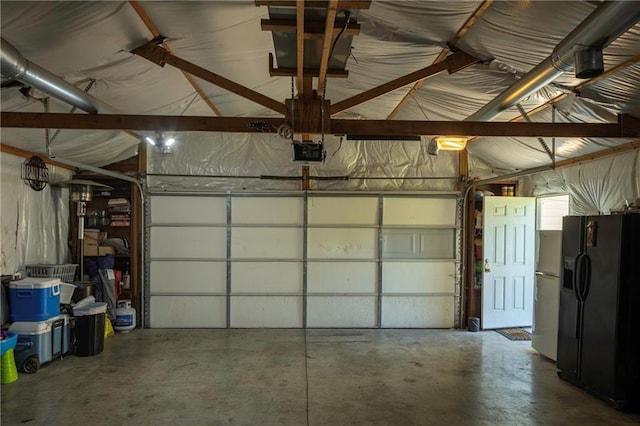 1934 E Mechanic Ave, Independence, MO 64050 - garage featuring black fridge, a garage door opener, and fridge with ice dispenser