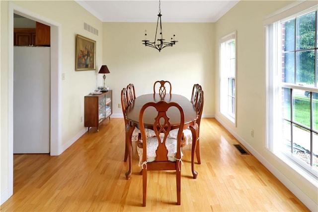 1503 Nottingham Dr, Warrensburg, MO 64093 - dining space with a chandelier, plenty of natural light, light wood-style floors, and crown molding