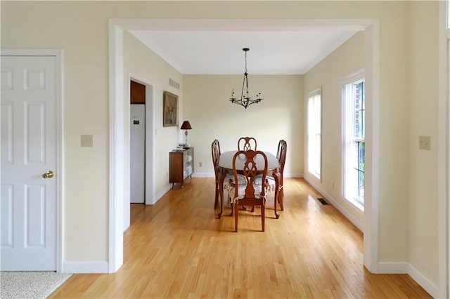 1503 Nottingham Dr, Warrensburg, MO 64093 - dining space with healthy amount of natural light, a chandelier, light wood-type flooring, and crown molding