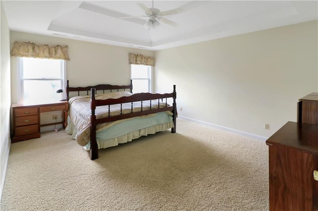 1503 Nottingham Dr, Warrensburg, MO 64093 - bedroom with light colored carpet, a raised ceiling, and a ceiling fan