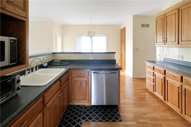 1503 Nottingham Dr, Warrensburg, MO 64093 - kitchen featuring dishwasher, light wood finished floors, dark countertops, and brown cabinets