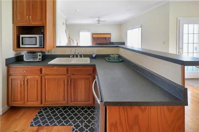 1503 Nottingham Dr, Warrensburg, MO 64093 - kitchen with appliances with stainless steel finishes, ceiling fan, plenty of natural light, brown cabinetry, and crown molding