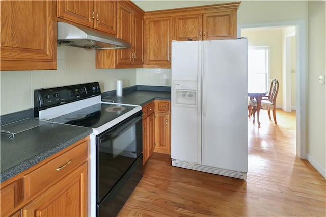 1503 Nottingham Dr, Warrensburg, MO 64093 - kitchen with white refrigerator with ice dispenser, electric range oven, under cabinet range hood, light wood-style floors, and brown cabinets