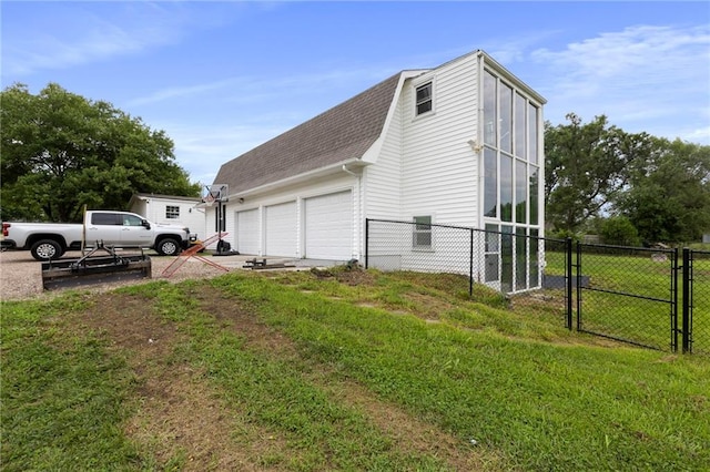 4901 E 215th St, Belton, MO 64012 - view of side of home with roof with shingles, a gate, driveway, and an attached garage