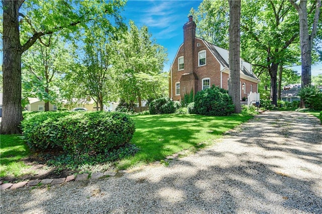 4912 W 69th St, Prairie Village, KS 66208 - view of home's exterior with a chimney, brick siding, and a yard