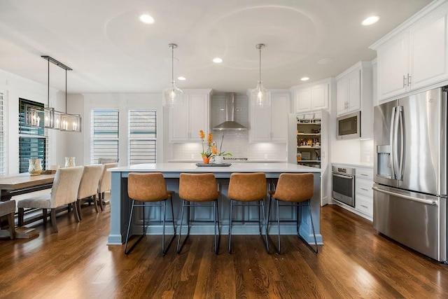 15801 Canterbury St, Overland Park, KS 66224 - kitchen with stainless steel appliances, wall chimney range hood, white cabinets, tasteful backsplash, and recessed lighting