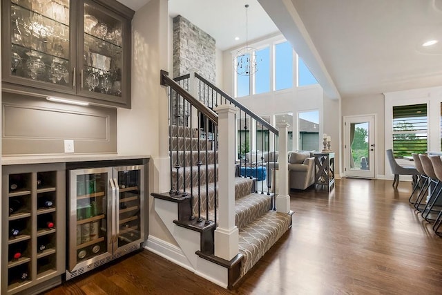 15801 Canterbury St, Overland Park, KS 66224 - stairs featuring wine cooler, wood finished floors, a chandelier, and a dry bar