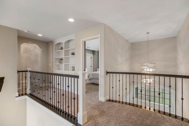 15801 Canterbury St, Overland Park, KS 66224 - hallway featuring carpet flooring, recessed lighting, built in shelves, an upstairs landing, and a chandelier