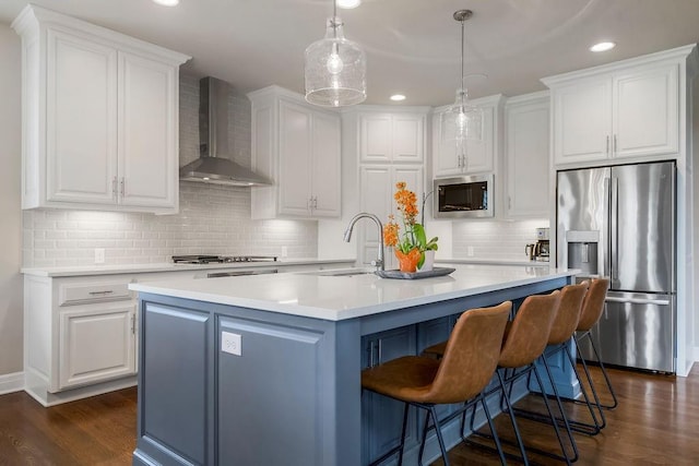 15801 Canterbury St, Overland Park, KS 66224 - kitchen featuring wall chimney exhaust hood, stainless steel appliances, white cabinets, dark wood-style flooring, and recessed lighting