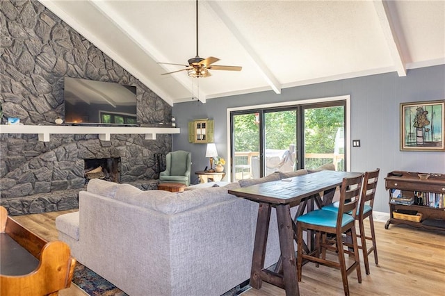 8605 Deer Run St, Lenexa, KS 66220 - living area featuring light wood-type flooring, a ceiling fan, and a stone fireplace