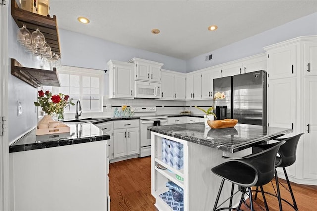 22116 W 51st St, Shawnee, KS 66226 - kitchen featuring white appliances, a center island, white cabinetry, dark wood-style flooring, and recessed lighting