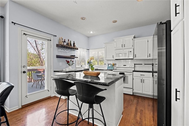 22116 W 51st St, Shawnee, KS 66226 - kitchen with white appliances, a center island, plenty of natural light, white cabinetry, and recessed lighting
