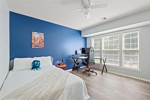 22116 W 51st St, Shawnee, KS 66226 - bedroom with wood finished floors, a textured ceiling, an office area, and ceiling fan
