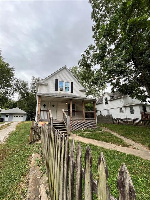 551 S Brookside Ave, Independence, MO 64053 - view of front facade featuring a porch, a detached garage, and driveway