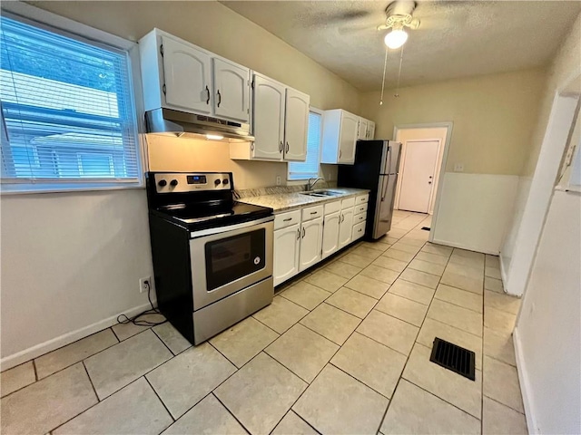 551 S Brookside Ave, Independence, MO 64053 - kitchen featuring appliances with stainless steel finishes, under cabinet range hood, healthy amount of natural light, white cabinetry, and a textured ceiling