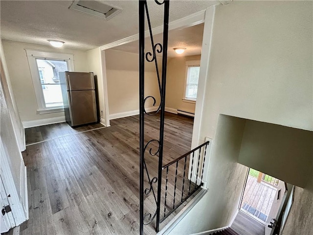 551 S Brookside Ave, Independence, MO 64053 - interior space featuring a textured ceiling, healthy amount of natural light, dark wood-style flooring, and a baseboard heating unit