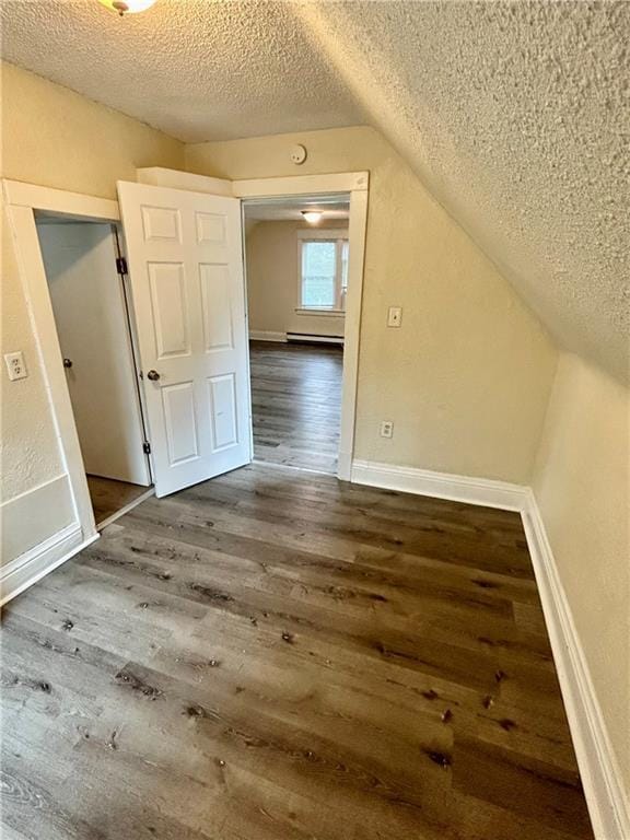 551 S Brookside Ave, Independence, MO 64053 - additional living space with a textured ceiling, wood finished floors, lofted ceiling, and baseboard heating
