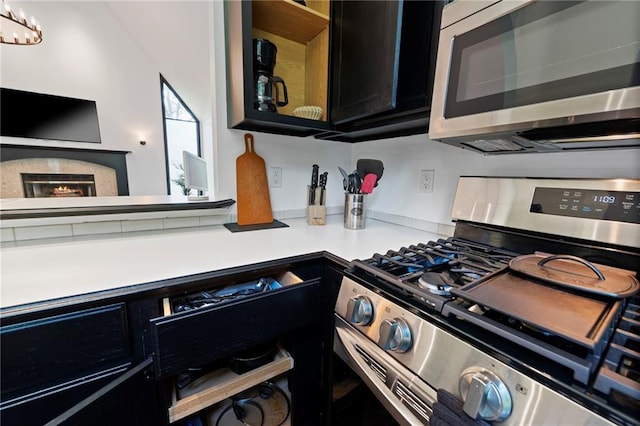 4813 NW Northwood Rd, Riverside, MO 64150 - kitchen featuring appliances with stainless steel finishes, light countertops, dark cabinets, and a premium fireplace