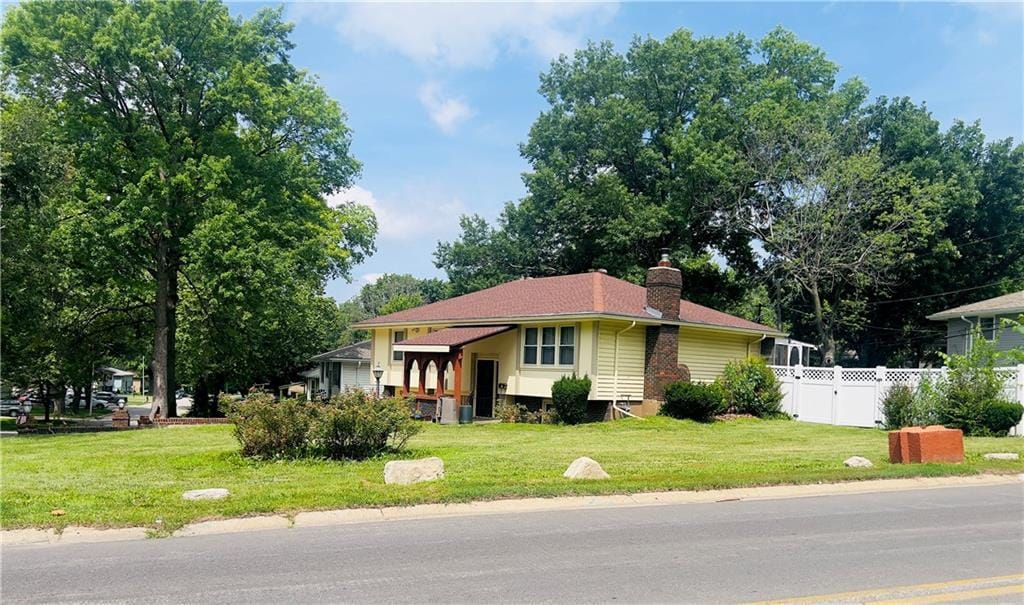 5708 E 100th St, Kansas City, MO 64137 - view of front facade featuring a chimney