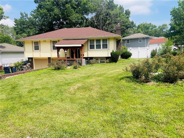 5708 E 100th St, Kansas City, MO 64137 - split foyer home with stucco siding, an attached garage, and a chimney