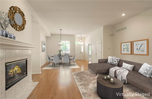 6306 W 128th St, Overland Park, KS 66209 - living room with wood finished floors, a tiled fireplace, and recessed lighting