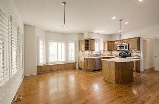 6306 W 128th St, Overland Park, KS 66209 - kitchen with stainless steel appliances, open shelves, a center island, decorative backsplash, and light countertops