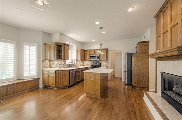 6306 W 128th St, Overland Park, KS 66209 - kitchen with appliances with stainless steel finishes, open shelves, wood finished floors, light countertops, and decorative backsplash